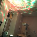 В углу аппарат на который ложат ребёнка. Справа большая угловая